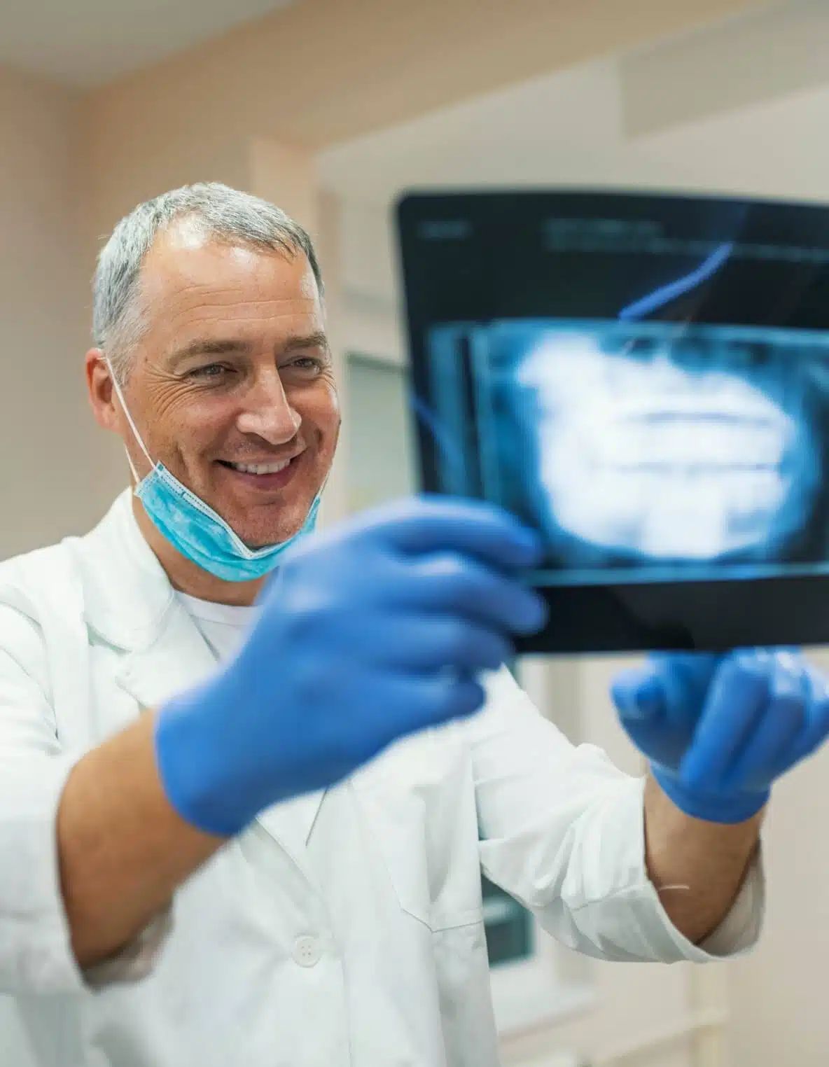 dentist looking at a panoramic X-ray of an implant patient